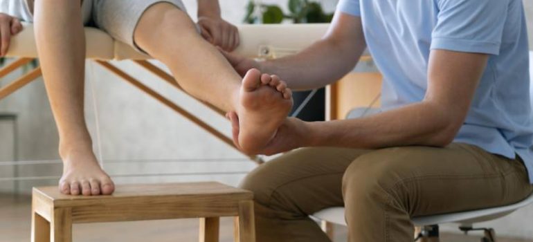 Patient receiving manual therapy for ankle ligament damage