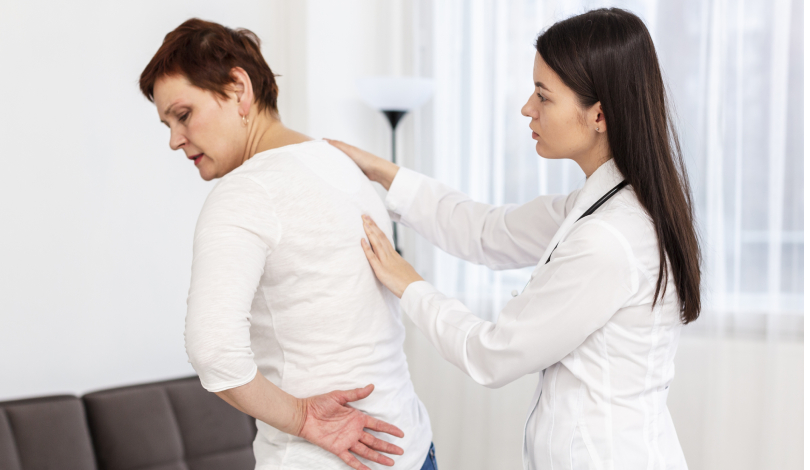 Physiotherapist providing back pain treatment with stretching exercises