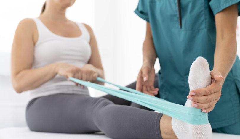 Physiotherapist assisting a patient with ankle sprain rehabilitation.