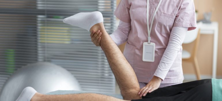 Physiotherapist guiding a patient through knee exercises