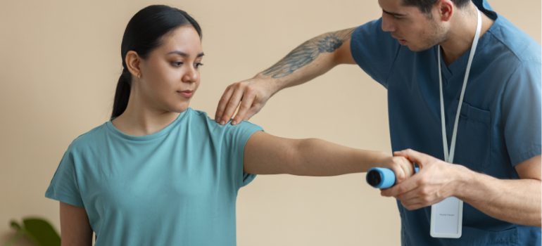 Physiotherapist assisting a patient with frozen shoulder exercises