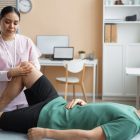 Physiotherapist assisting a patient with knee strengthening exercises.