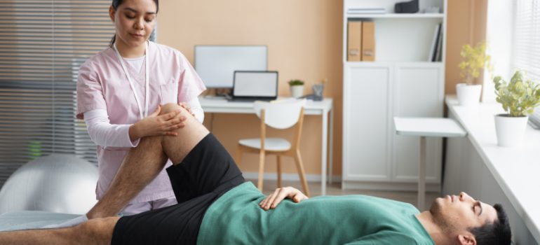 Physiotherapist assisting a patient with knee strengthening exercises.