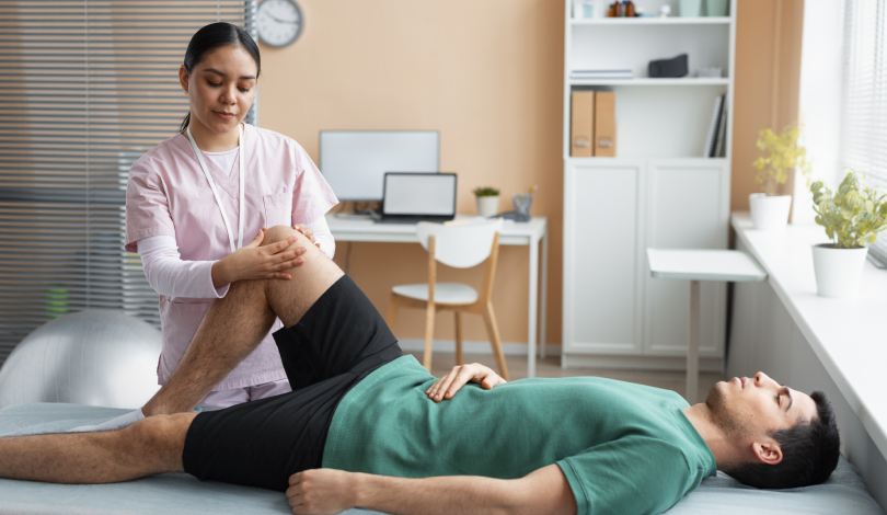 Physiotherapist assisting a patient with knee strengthening exercises.