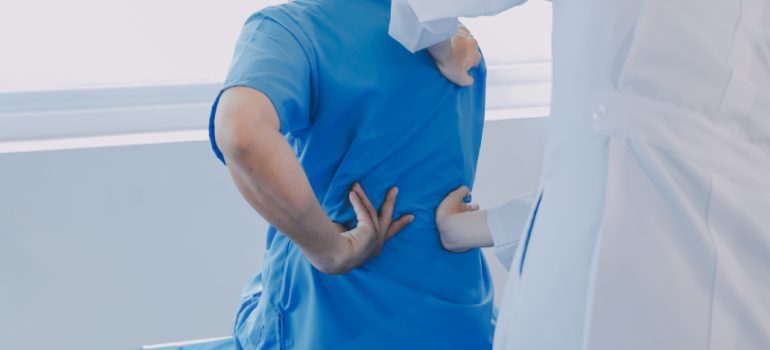 Physiotherapist assisting a patient with back strengthening exercises