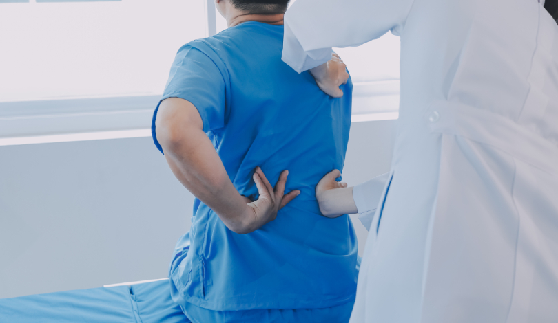 Physiotherapist assisting a patient with back strengthening exercises