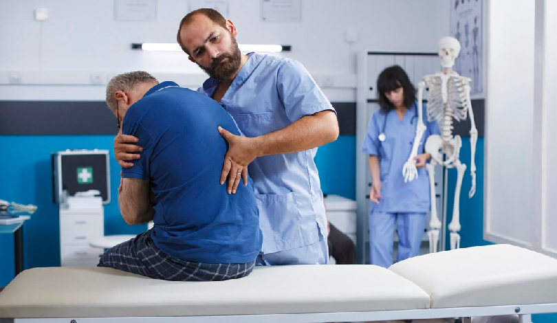 Patient undergoing physiotherapy after surgery for back pain recovery.