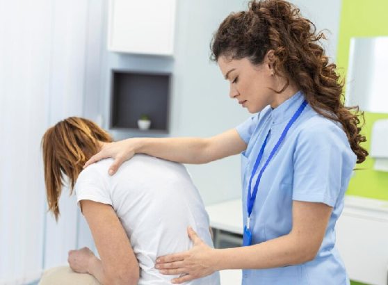 Physiotherapist assisting a patient with lower back pain rehabilitation.