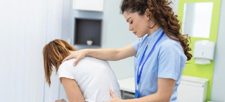 Physiotherapist assisting a patient with lower back pain rehabilitation.