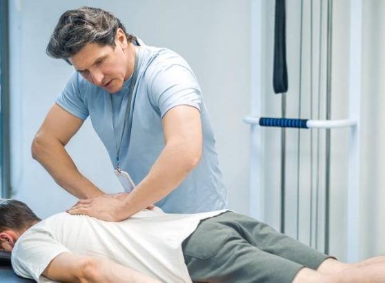 Physiotherapist assisting a patient with spinal physiotherapy treatment.